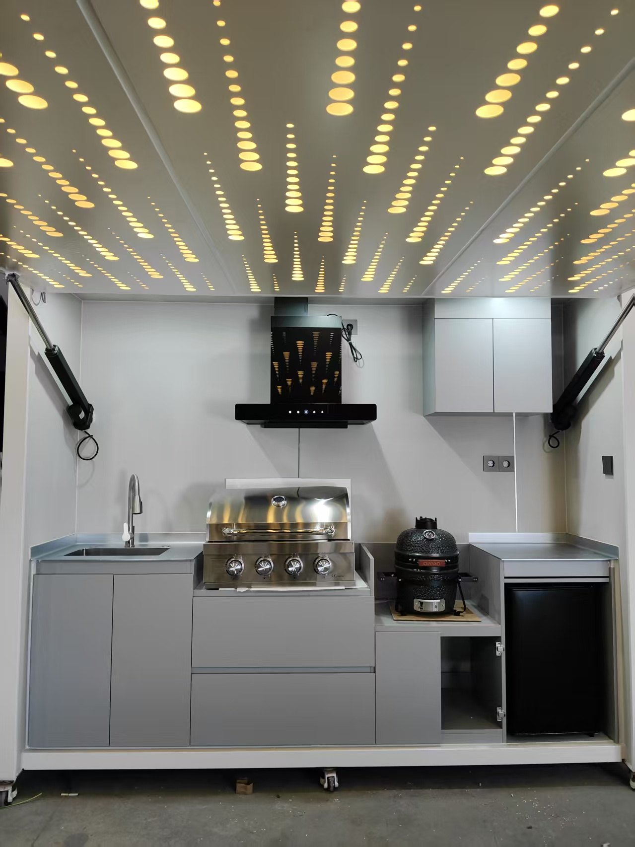 White modular outdoor kitchen island with starry ceiling lights